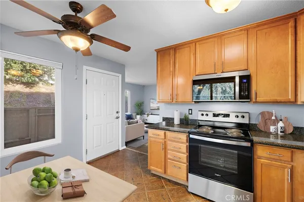 a kitchen with stainless steel appliances granite countertop a stove a sink and a microwave