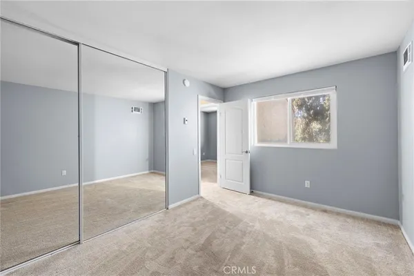 a view of an empty room with closet and a window