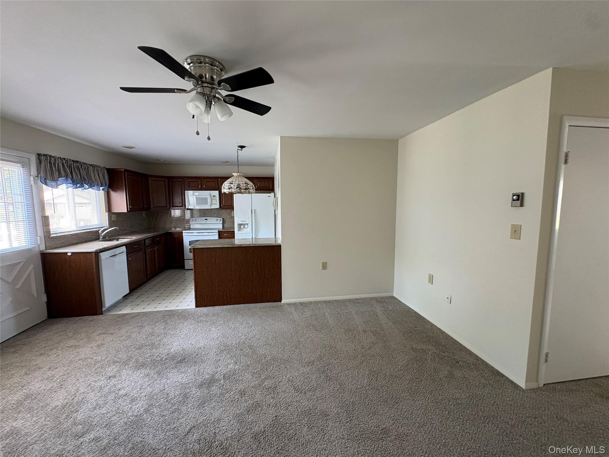 491 Stratford Lane Ridge, NY 11961 - Photo 12 of 24 a kitchen with stainless steel appliances kitchen island granite countertop a refrigerator and a sink