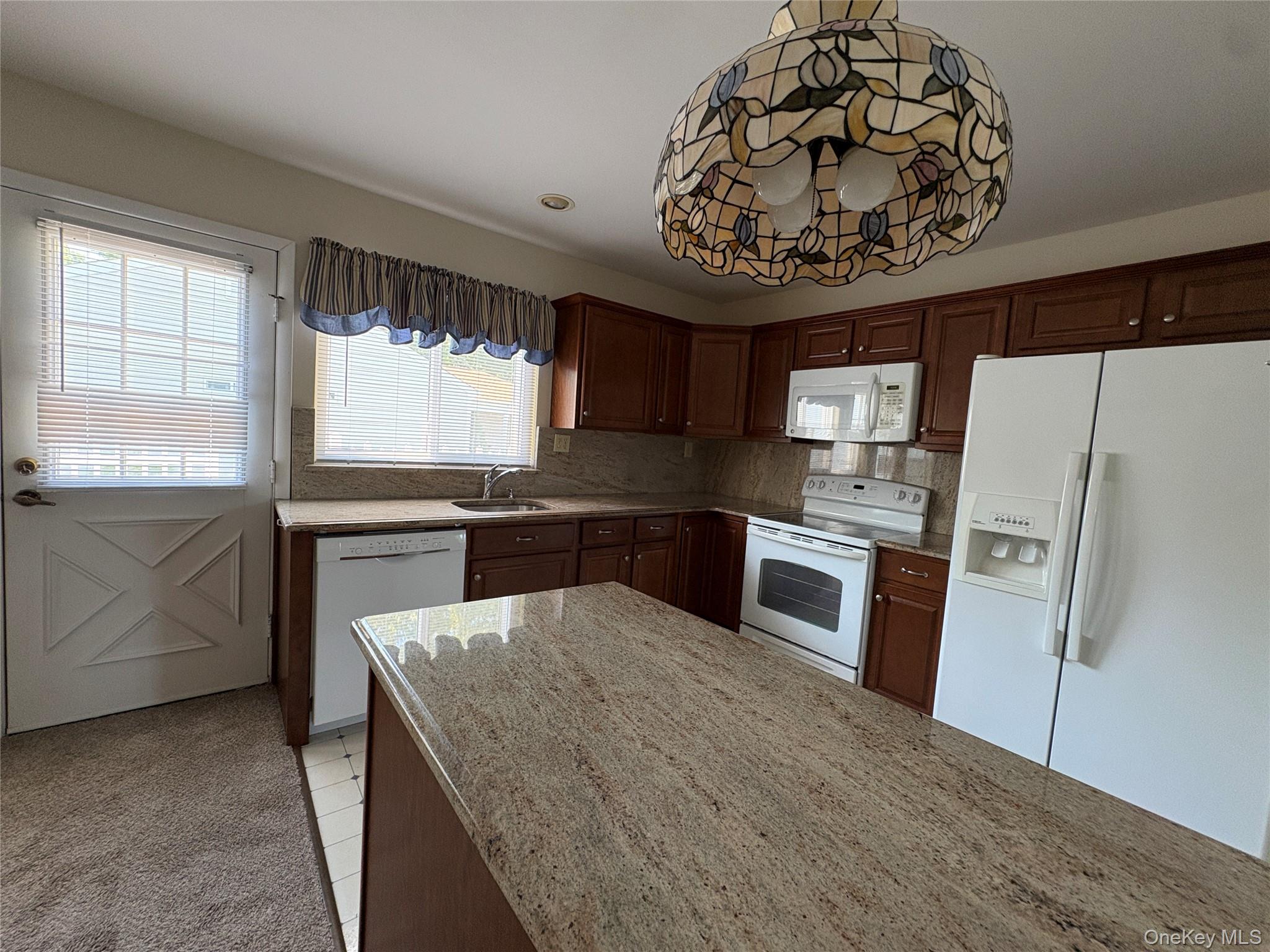491 Stratford Lane Ridge, NY 11961 - Photo 14 of 24 a kitchen with a refrigerator and a stove top oven