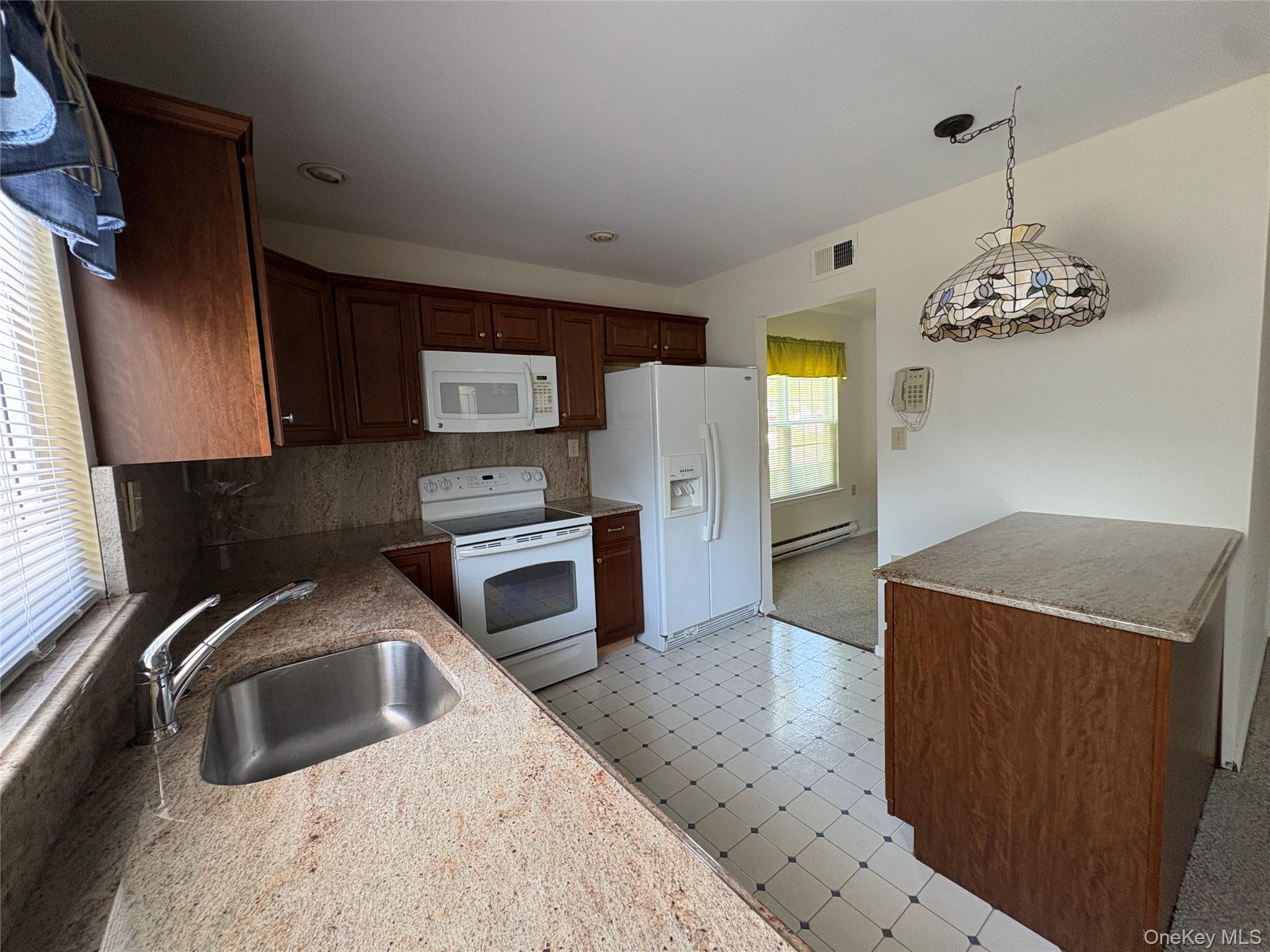 491 Stratford Lane Ridge, NY 11961 - Photo 15 of 24 a kitchen with stainless steel appliances granite countertop a sink a stove and a refrigerator