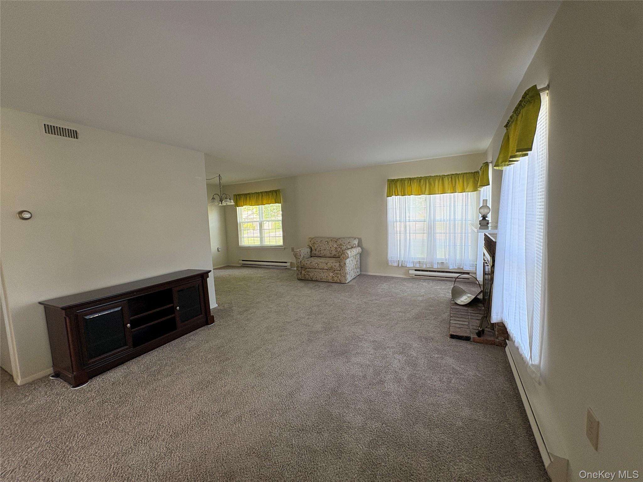 491 Stratford Lane Ridge, NY 11961 - Photo 3 of 24 a living room with furniture and a window
