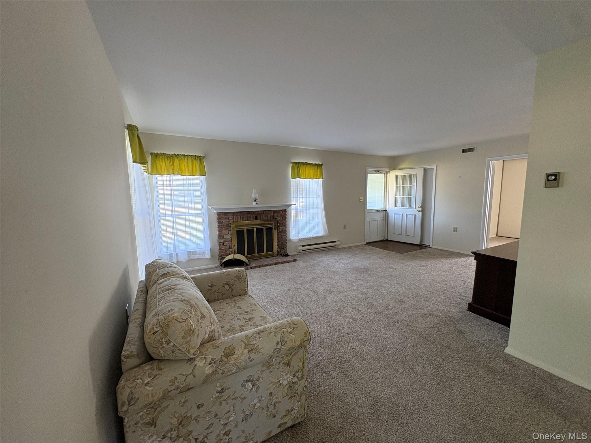 491 Stratford Lane Ridge, NY 11961 - Photo 4 of 24 a living room with furniture and a fireplace