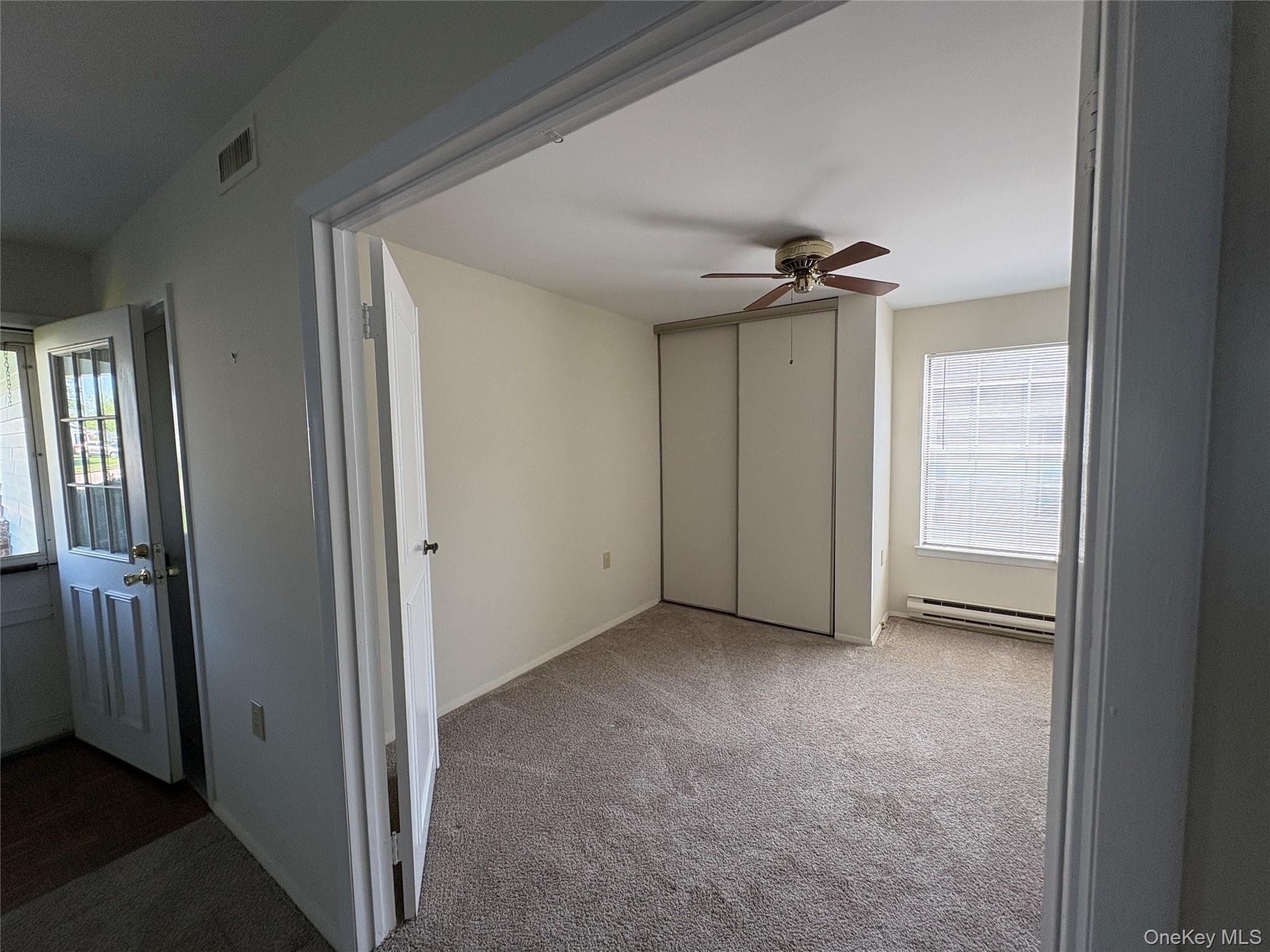 491 Stratford Lane Ridge, NY 11961 - Photo 6 of 24 an empty room and a ceiling fan