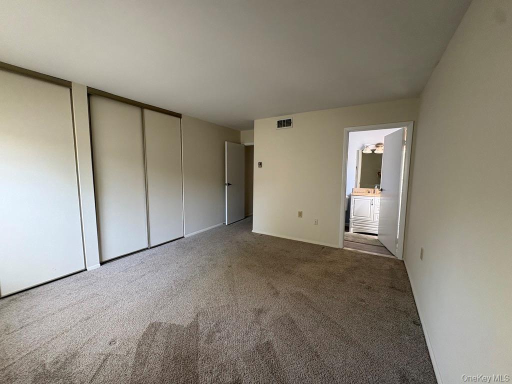 491 Stratford Lane Ridge, NY 11961 - Photo 9 of 24 an empty room with closet and mirror