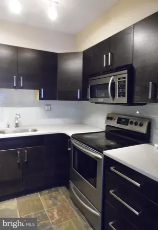 a kitchen with wooden cabinets and a stove top oven