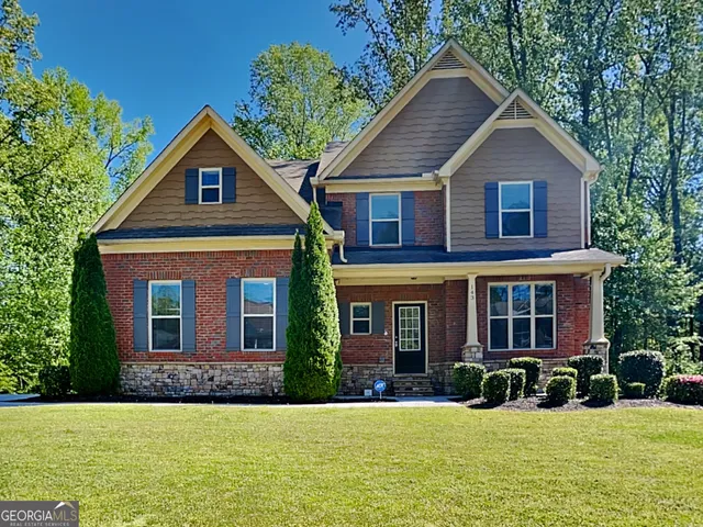 a front view of a house with yard and green space