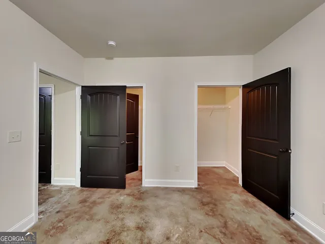 an empty room with closet and a hallway