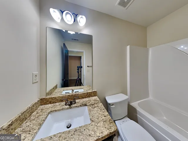 a bathroom with a sink a toilet and a mirror
