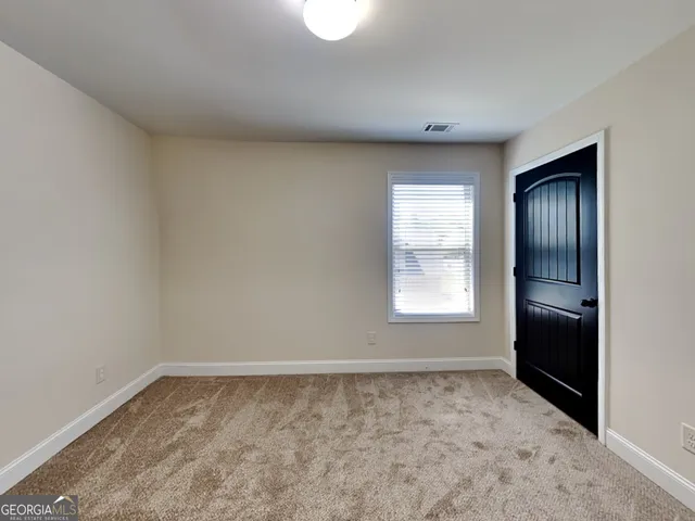 an empty room with closet and entrance