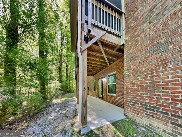 a view of a yard with plants and large trees