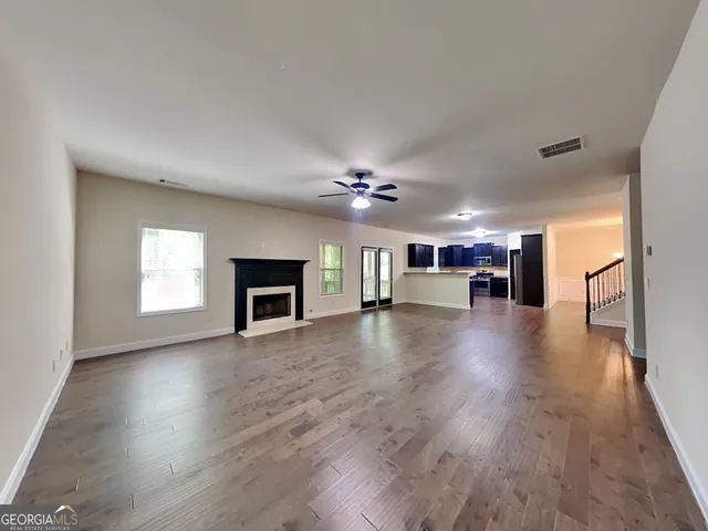 a view of a livingroom with a ceiling fan and hardwood floor