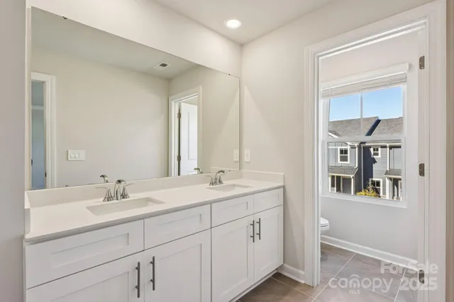 a bathroom with a double vanity sink and a mirror
