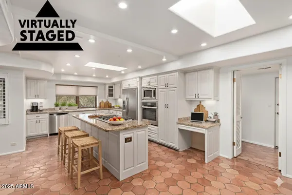 a kitchen with stainless steel appliances kitchen island granite countertop a sink and cabinets