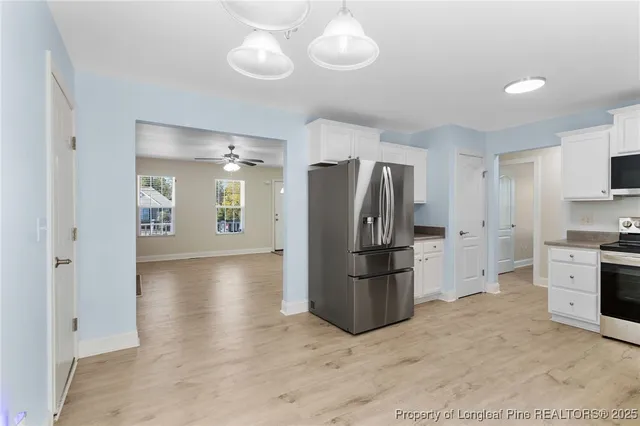 a kitchen with a refrigerator a stove top oven and cabinets