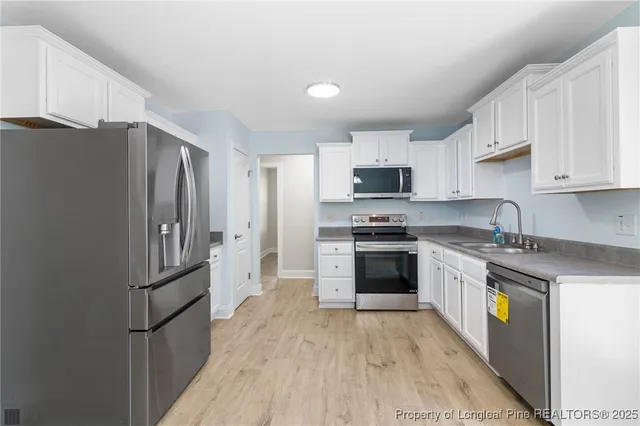 a kitchen with stainless steel appliances granite countertop a refrigerator stove and sink