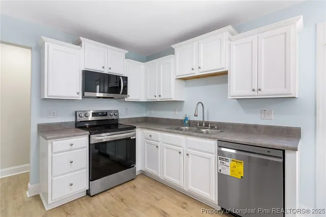 a kitchen with stainless steel appliances granite countertop a sink stove and microwave