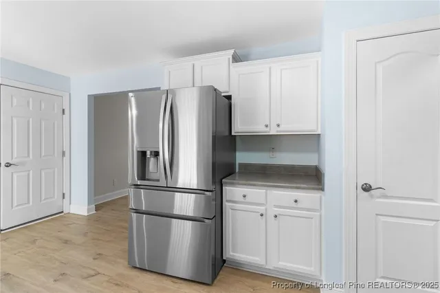 a kitchen with granite countertop white cabinets and stainless steel appliances
