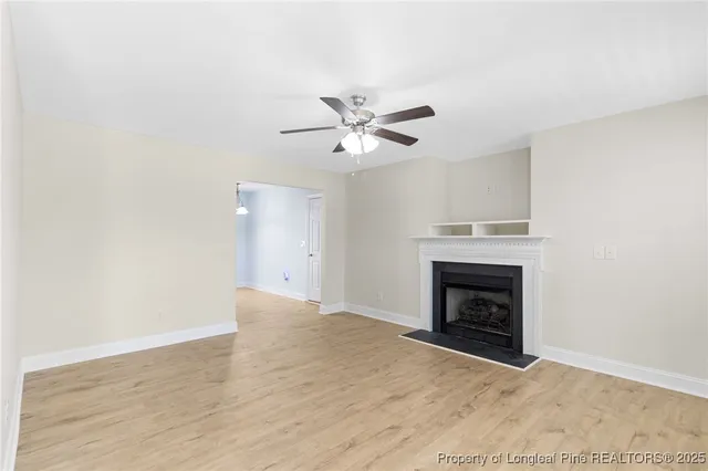 an empty room with fireplace and fan