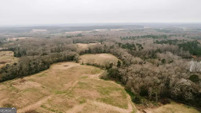 a view of a dry yard covered with snow in the background