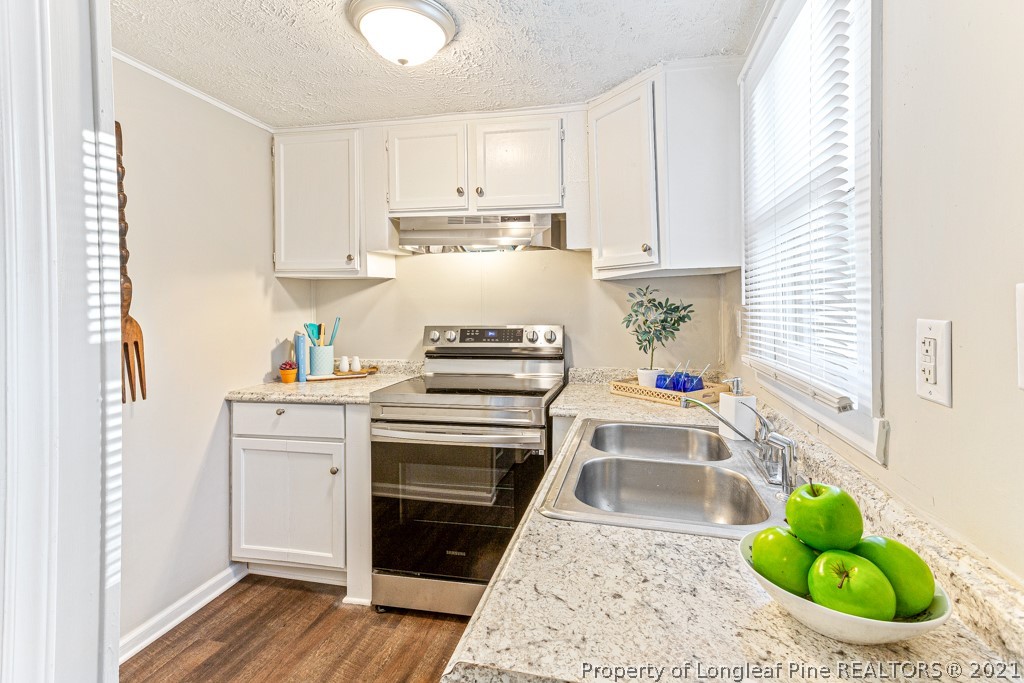 227 H T Kelly Road Cameron, NC 28326 - Photo 14 of 29 a kitchen with white cabinets and appliances
