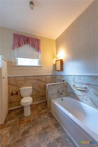 an empty room with windows and ceiling fan