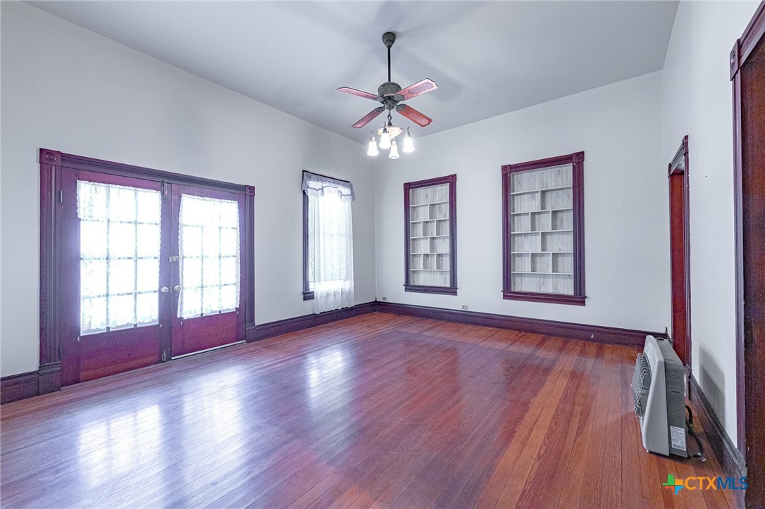 1306 Ave G Shiner, TX 77984 - Photo 6 of 23 a view of an empty room with wooden floor and a window