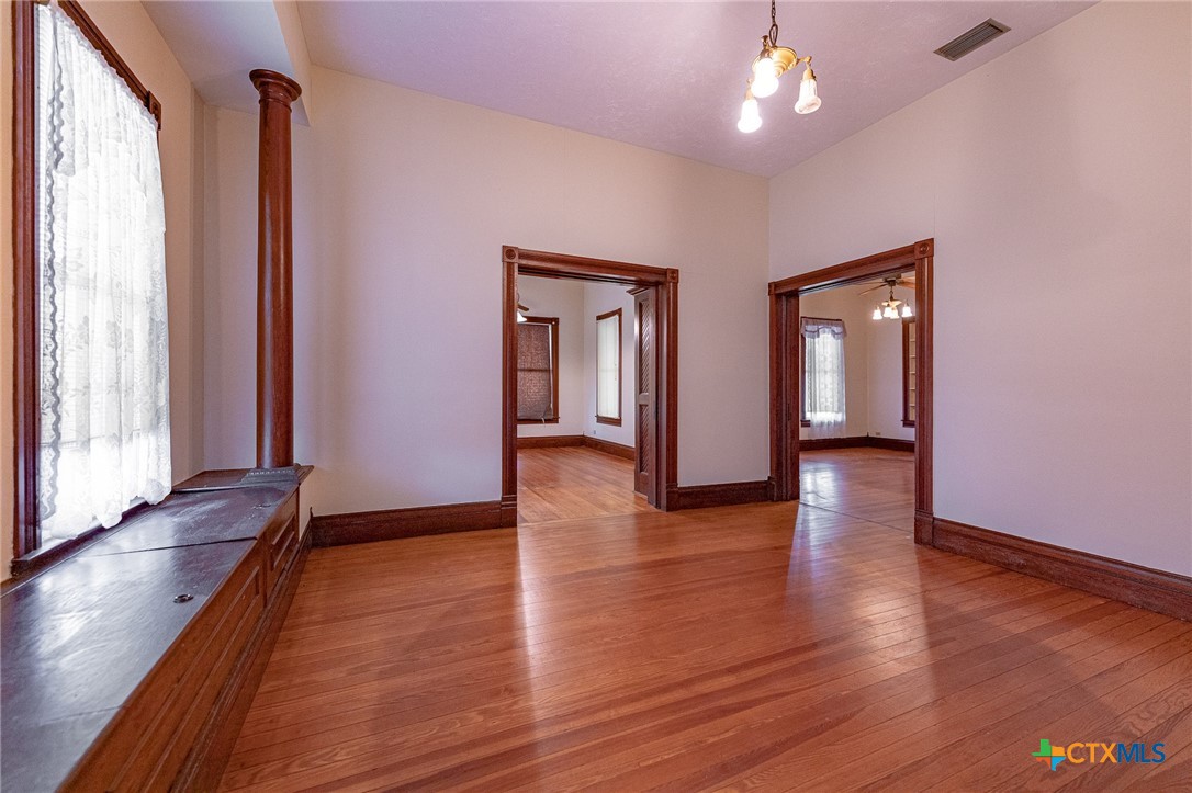 1306 Ave G Shiner, TX 77984 - Photo 10 of 23 an empty room with wooden floor and windows