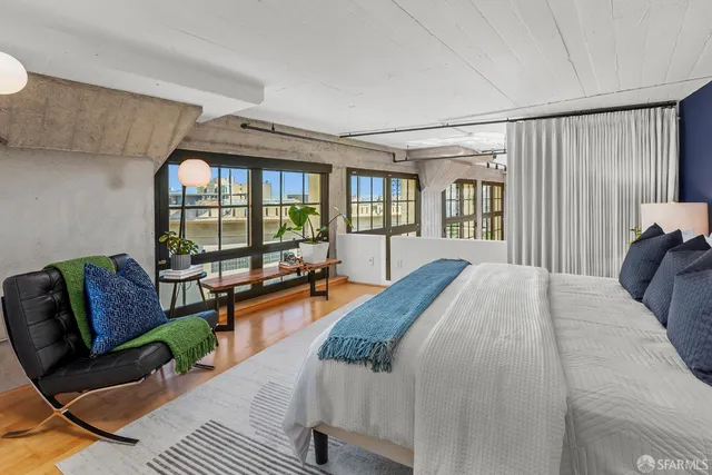 a bed sitting in a spacious bedroom next to a window