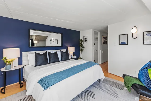 a large bedroom with bed and paintings on wall