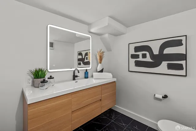 a bathroom with a toilet sink and mirror