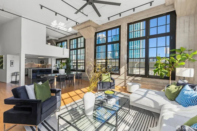 a living room with furniture and floor to ceiling windows