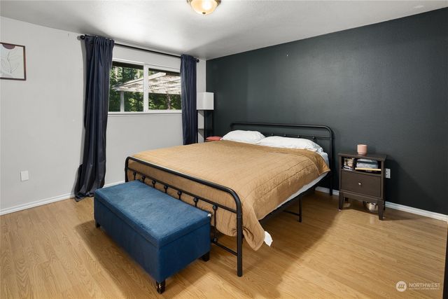 a bedroom with a bed window and wooden floor