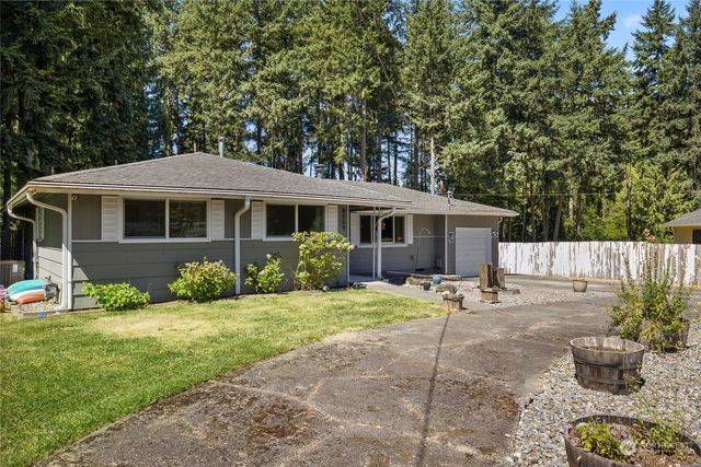 a front view of a house with a yard and potted plants