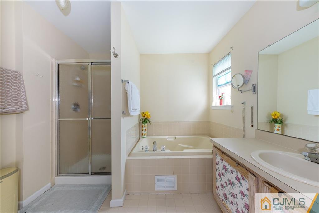 6 Yorkshire Village Road Lawrence Township, NJ 08648 - Photo 24 of 30 a bathroom with a granite countertop tub sink and mirror