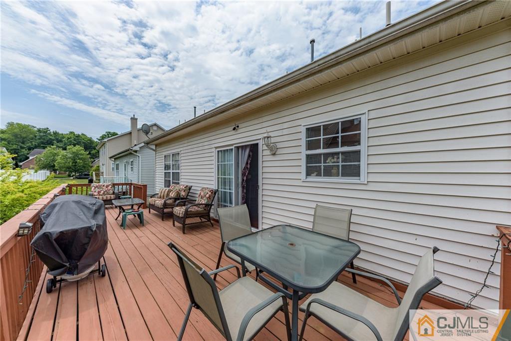 6 Yorkshire Village Road Lawrence Township, NJ 08648 - Photo 27 of 30 a view of a patio with table and chairs with wooden floor and fence