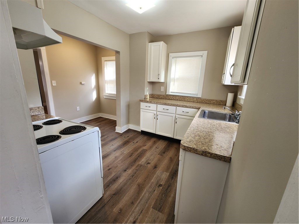 3586 Cedarbrook Road Cleveland, OH 44118 - Photo 12 of 30 Kitchen with range hood, stove, dark hardwood / wood-style flooring, and white cabinetry