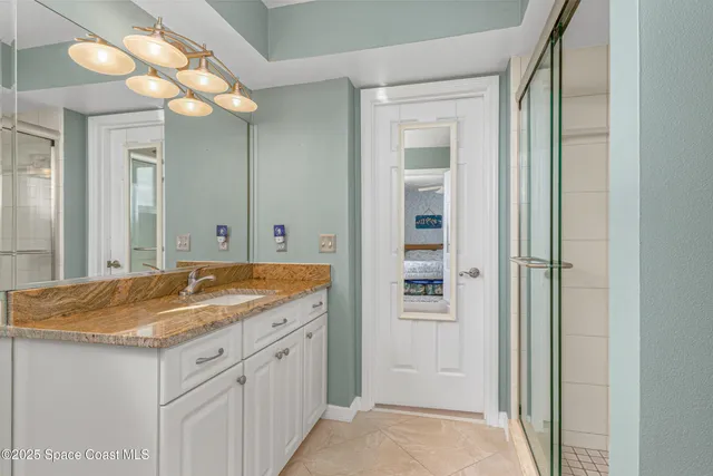 a bathroom with a granite countertop sink a mirror and a shower