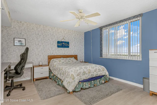 a bed sitting in a bedroom next to a large window