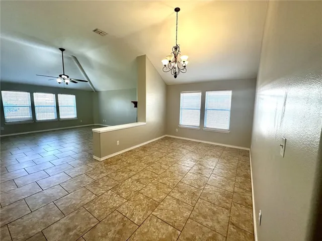 an empty room with windows and fireplace