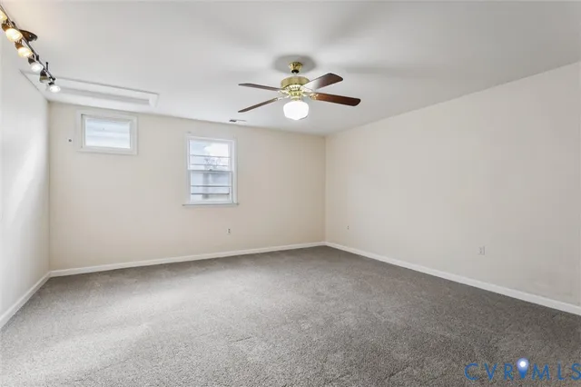 an empty room with a window and a ceiling fan