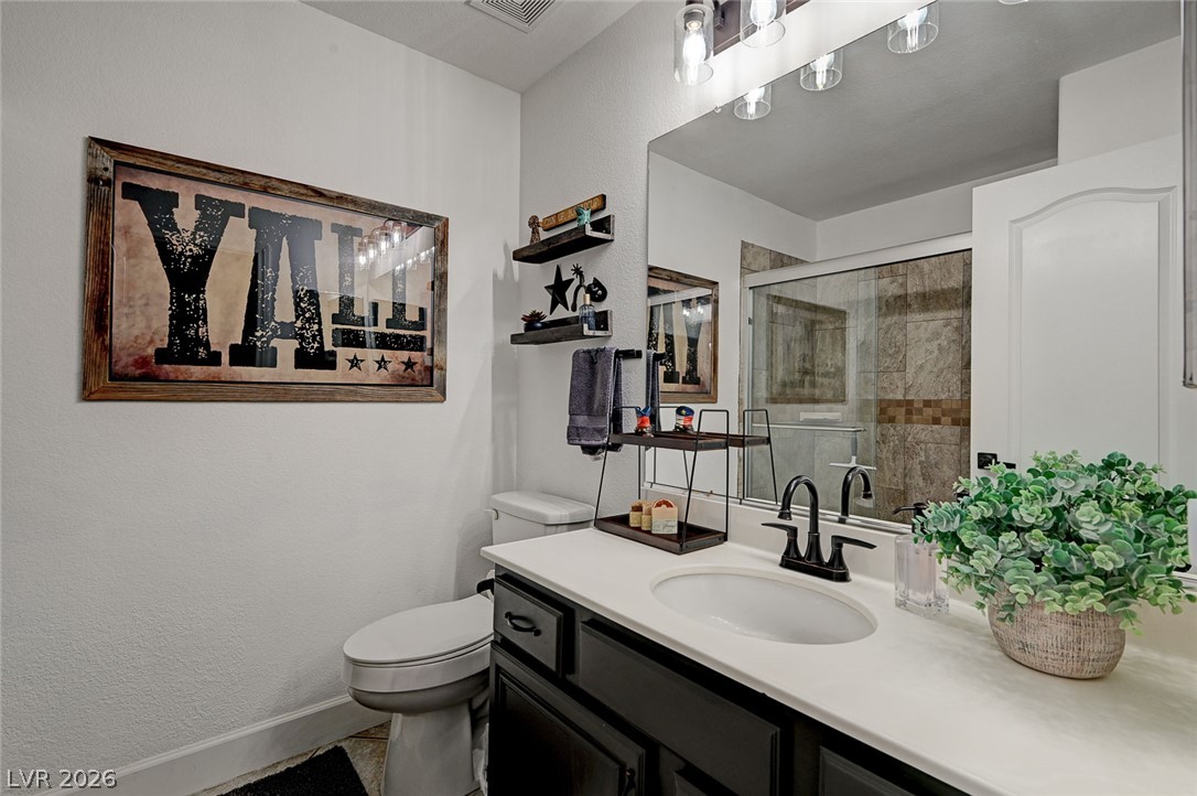 1072 Reed Point Court Henderson, NV 89002 - Photo 39 of 60 A well-appointed bathroom features a single vanity, a sleek toilet, and a glass-enclosed shower, perfect for daily routines.