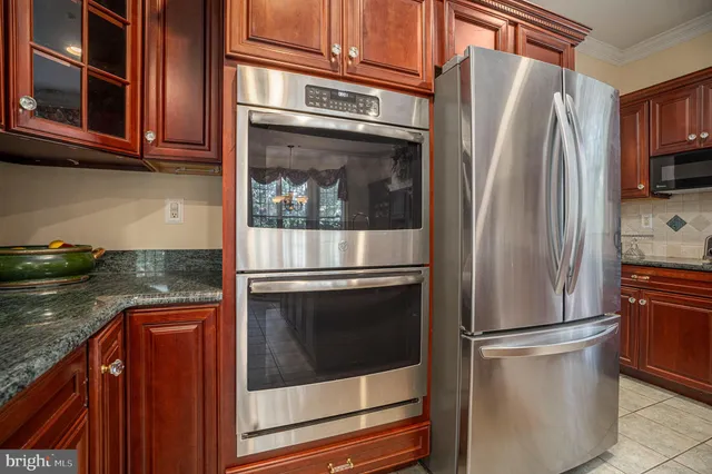 a metallic refrigerator freezer sitting in a kitchen