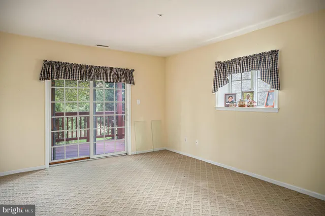 a view of empty room with wooden floor and windows