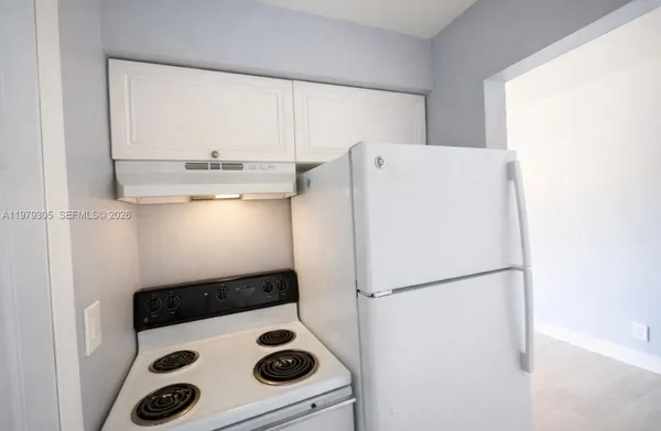 a white refrigerator freezer sitting inside of a kitchen