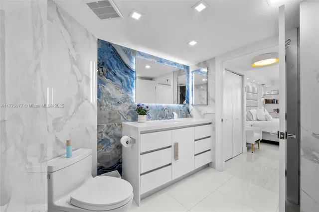 a bathroom with a sink vanity mirror and toilet