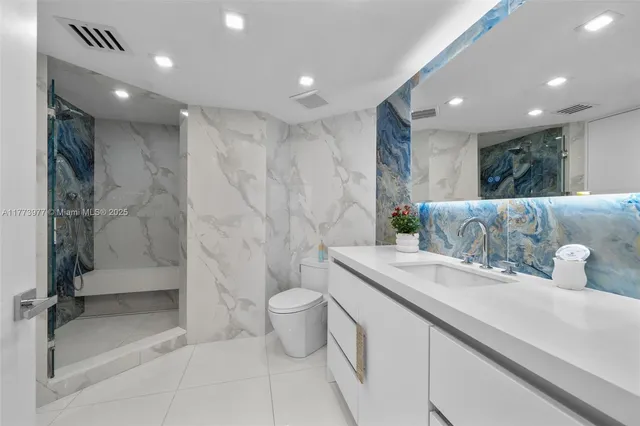 a bathroom with a granite countertop sink a toilet and shower
