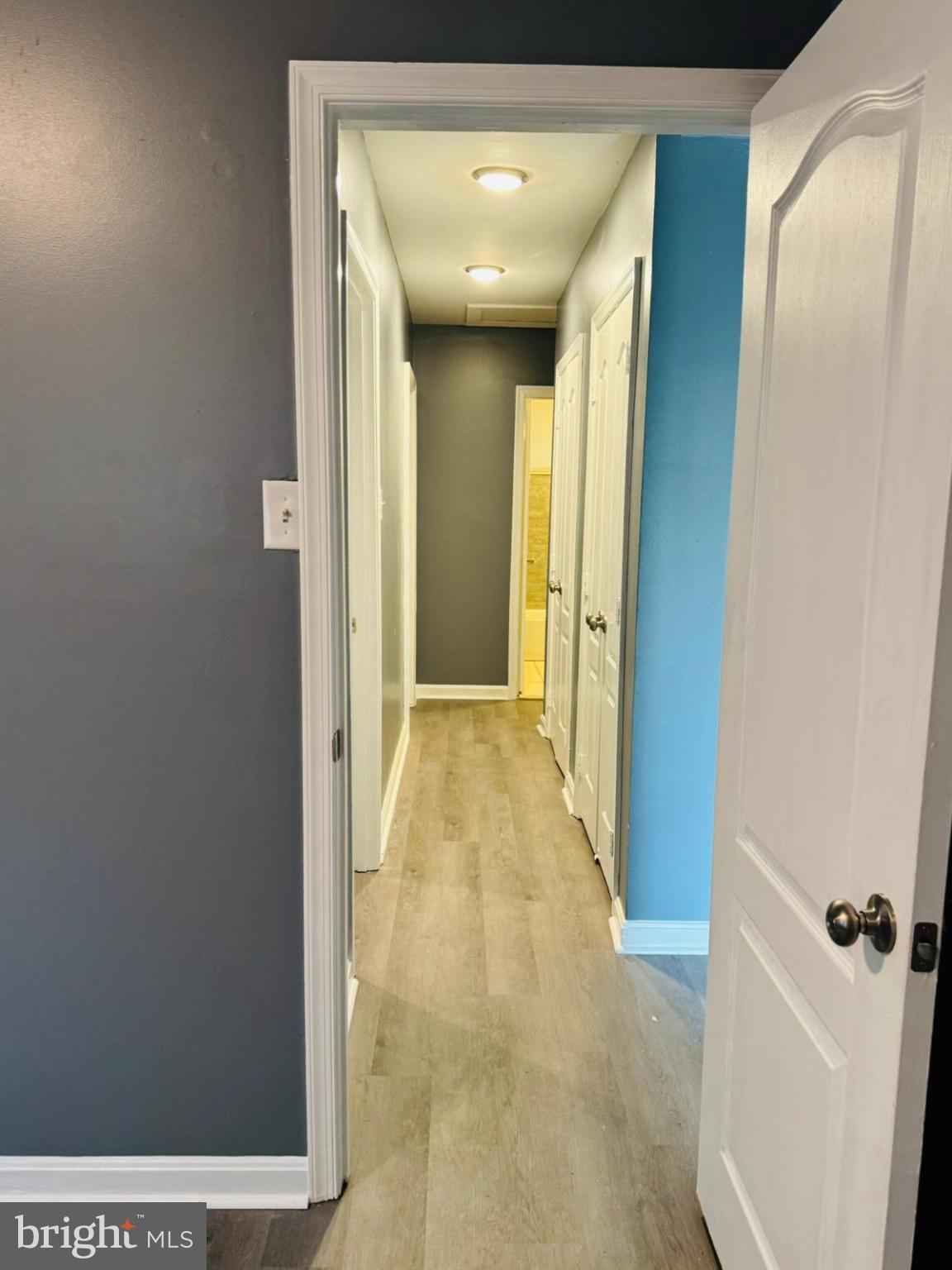 7719 Normandy Road Landover, MD 20785 - Photo 11 of 18 a view of a hallway with wooden floor and a bathroom
