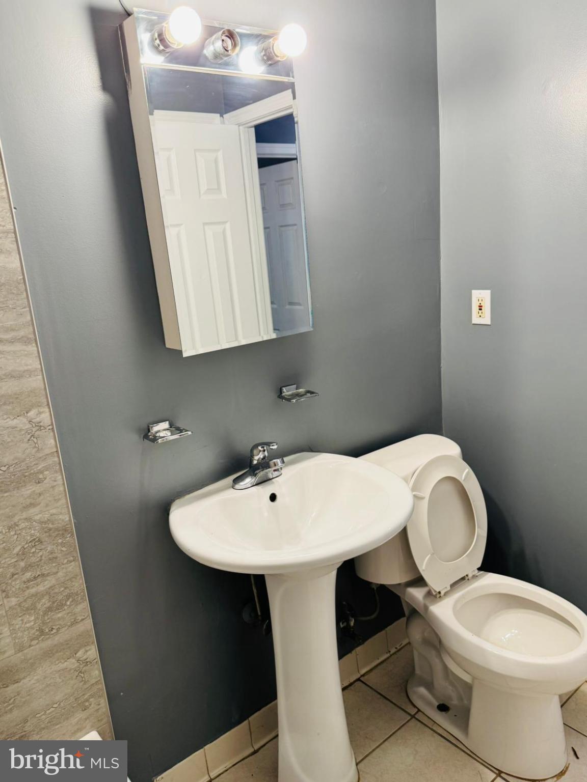 7719 Normandy Road Landover, MD 20785 - Photo 16 of 18 a bathroom with a toilet a sink and mirror