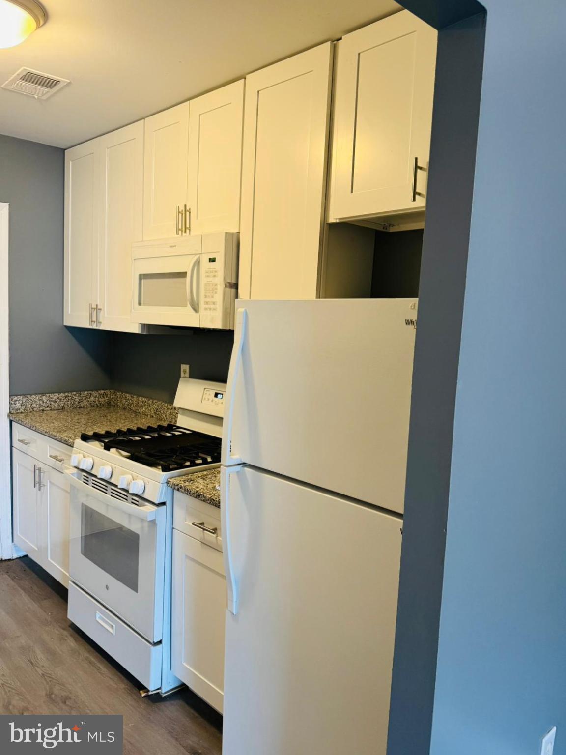 7719 Normandy Road Landover, MD 20785 - Photo 8 of 18 a kitchen with a white cabinets and a stove